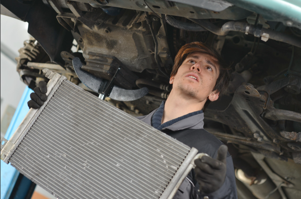A mechanic working on the underside of a car in the Wellington, OH area.