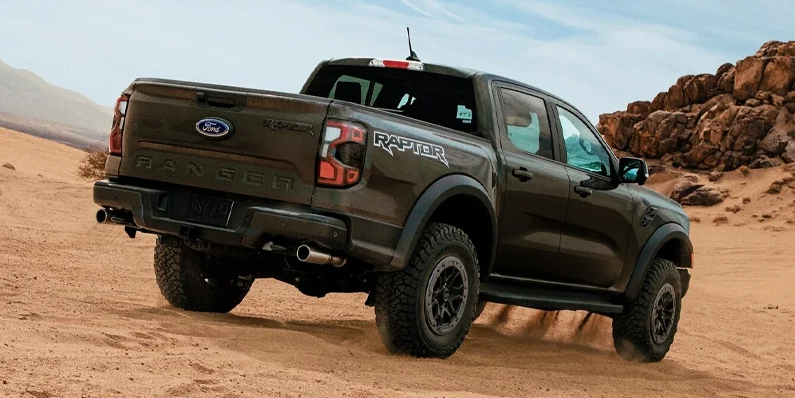A dark green 2025 Ford Ranger driving down a sandy hill.