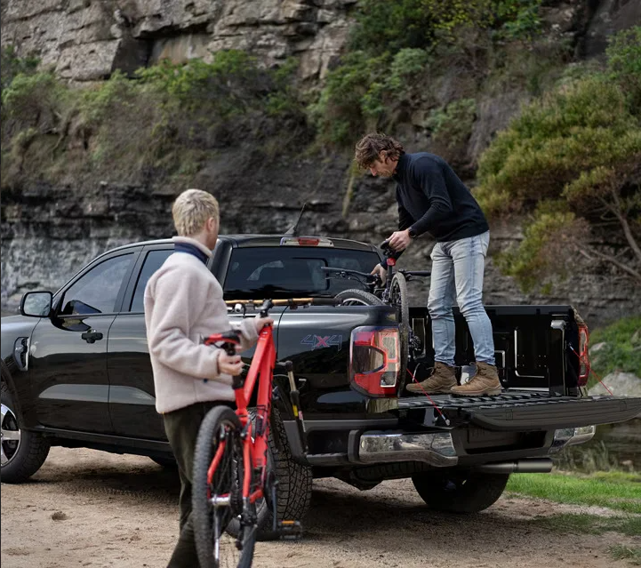 Two men loading bikes in to the back of a 2025 Ford Ranger.
