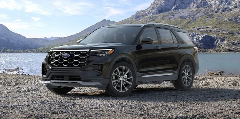 a Black 2025 Ford Explorer parked on a rocky beach.